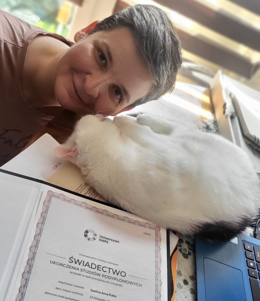 Dyplomowana kocia behawiorystka prezentująca świadectwo ukończenia studiów podyplomowych